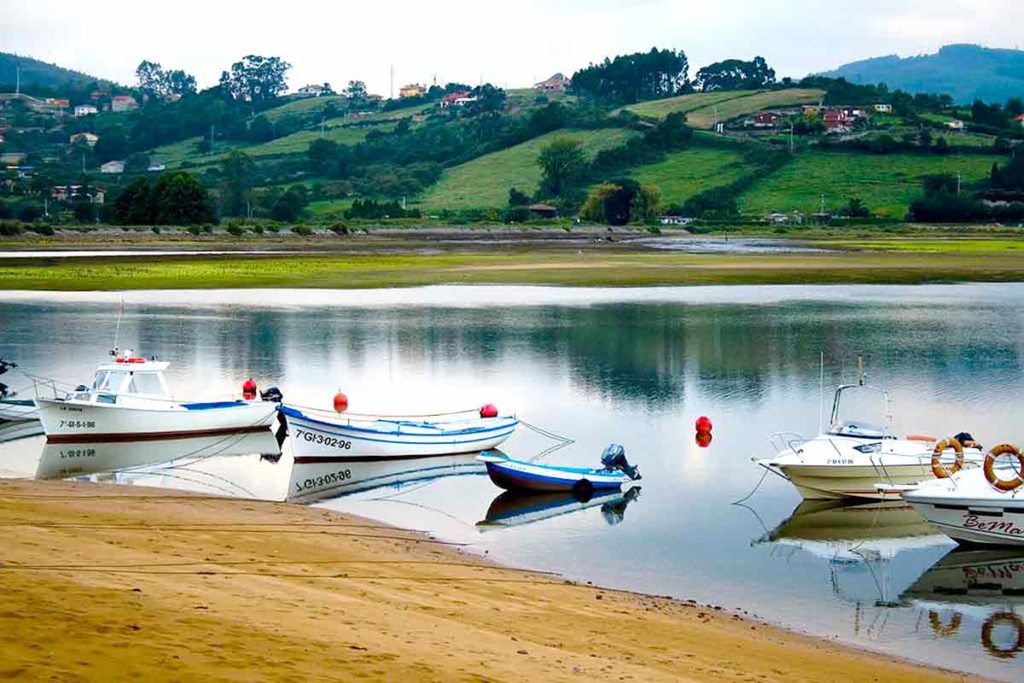 Lanchas amarradas en la ría de Villaviciosa, lugar de magia y misterio en Asturias